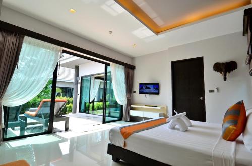 a bedroom with a bed and a large window at Chaweng Noi Pool Villa in Chaweng Noi Beach