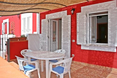 Maridea - Fragolino في بونسا: طاولة وكراسي على فناء بجدار احمر