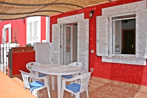 a table and chairs on a patio with a red wall at Maridea - Fragolino in Ponza