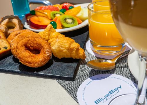 un tavolo con un piatto di cibo e un bicchiere di succo d'arancia di BlueBay Lanzarote a Costa Teguise