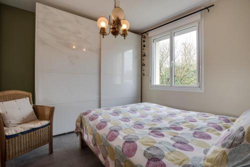 a bedroom with a bed and a window at Ti Cairn in Moëlan-sur-Mer
