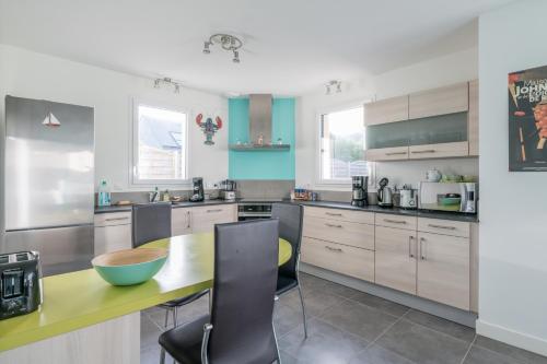 une cuisine avec une table et des chaises dans l'établissement TIEGEZH - Maison familiale Carantec, à Carantec
