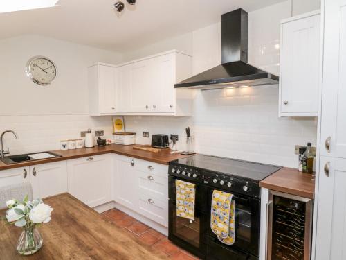 a kitchen with white cabinets and a black stove top oven at Ivy Bank in Thornhill