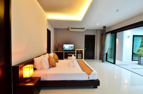 a bedroom with a large bed and a television at Chaweng Noi Pool Villa in Chaweng Noi Beach