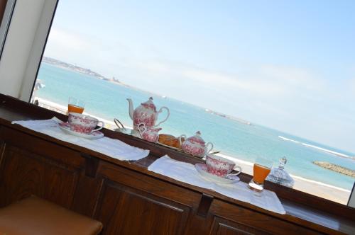 a table with a view of the beach from a window at Ayenac in Saint-Jean-de-Luz