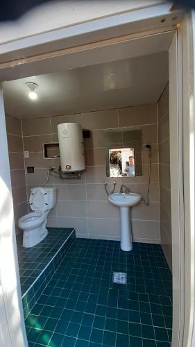 a bathroom with two toilets and a sink at Dasanbang Pension in Yangyang