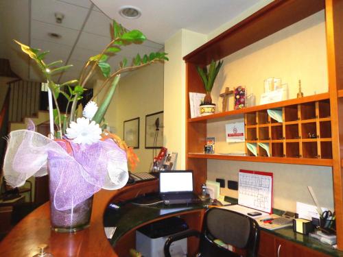 an office with a desk with a vase of flowers at Hotel Select in Montecchio Emilia