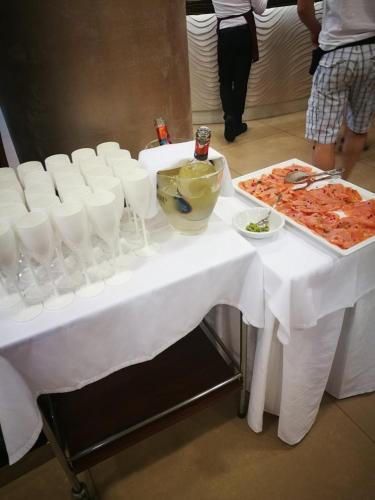 a table with a white table cloth and a tray of food at Hotel Lido Bibione Beach in Bibione