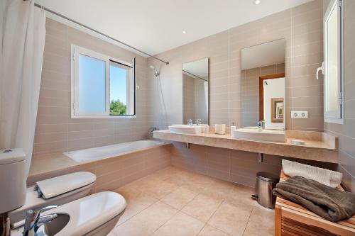 y baño con 2 lavabos, bañera y aseo. en Villa Marisa II, en Alcudia