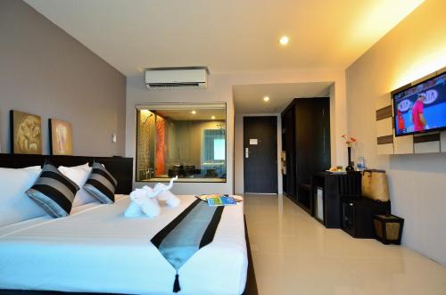 a bedroom with a large bed with a flat screen tv at Chaweng Noi Pool Villa in Chaweng Noi Beach