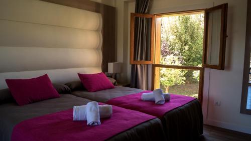 1 dormitorio con 1 cama grande con sábanas rosas y ventana en Albir Garden Resort en Albir