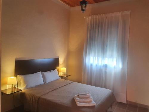 a bedroom with a bed with two towels on it at Alojamiento Rural Flamingo in El Rocío