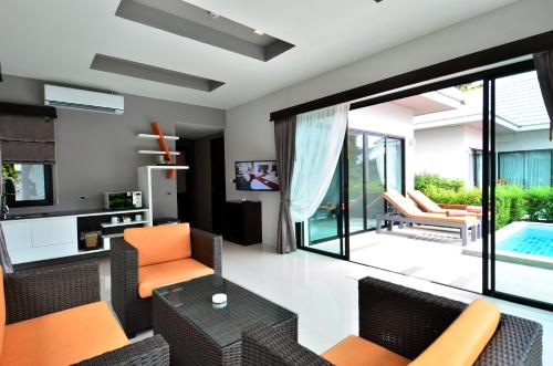 a living room with orange chairs and a swimming pool at Chaweng Noi Pool Villa in Chaweng Noi Beach