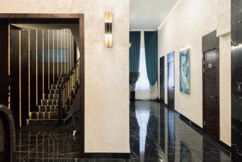 a hallway with a staircase with black tile at NCityHotel in Astana
