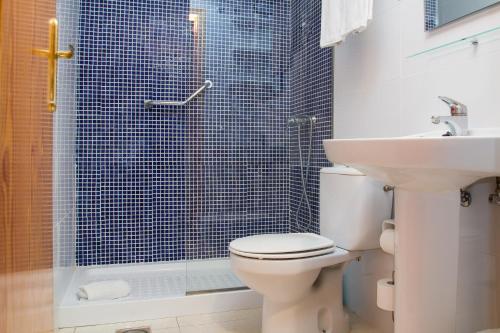 a bathroom with a toilet and a shower and a sink at Albir Garden Resort in Albir