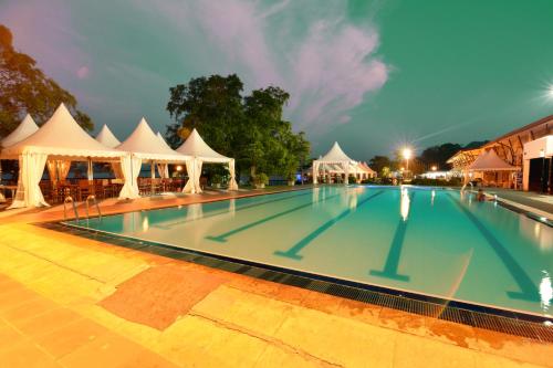 a large swimming pool with white tents and tents at Ramadia Ran Mal Holiday Resort in Moratuwa