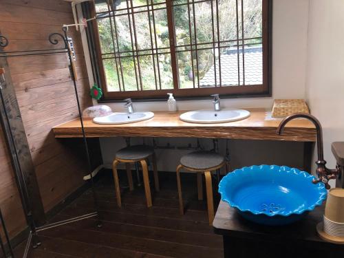 een badkamer met 2 wastafels en een raam bij Sanchouka in Saga