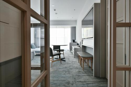 a view of a living room with a table and chairs at Lequ Okinawa Chatan Spa ＆ Resort in Chatan