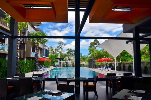 a view of a pool from a restaurant with tables and chairs at Chaweng Noi Pool Villa in Chaweng Noi Beach