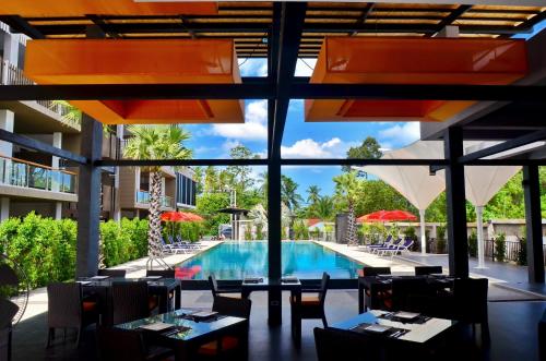 a restaurant with a pool and tables and chairs at Chaweng Noi Pool Villa in Chaweng Noi Beach