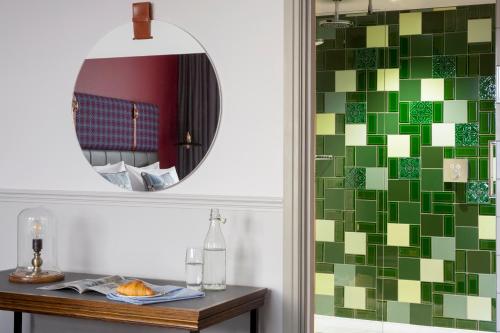 a bathroom with a mirror and a table at Hotel Indigo - Cardiff by IHG in Cardiff