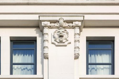 a white building with two windows and a crest at Hotel Indigo - Cardiff by IHG in Cardiff