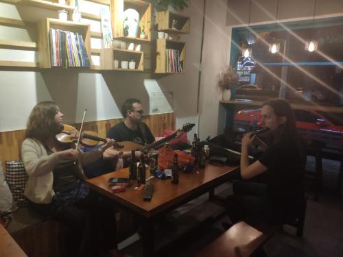 a group of people sitting around a table playing instruments at Suzhou Blue Gate Youth Hostel in Suzhou