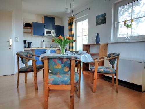 a kitchen with a table and chairs with a vase of flowers at Koserow_Jugendweg_FeWo 16 in Ostseebad Koserow