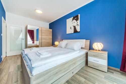 Un dormitorio con una cama grande con una pared azul. en REZIDENCE ŠVEHLOVA, en Praga