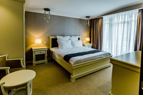 a hotel room with a bed and a table at HOTEL CARPAT INN in Azuga