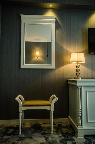 a bench in a room with a mirror and a lamp at HOTEL CARPAT INN in Azuga