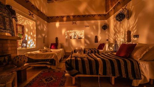 a bedroom with two beds in a room with lights at Dar Essalama Dades in Akhendachou nʼAït Ouffi
