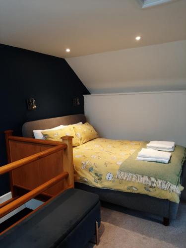 1 dormitorio con cama y banco. en The Well house, en Ilfracombe