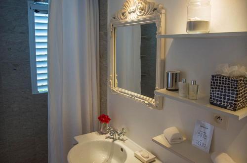 Baño blanco con lavabo y espejo en Dream Villa St-Jean 597, en Saint Barthelemy