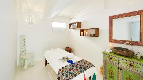 1 dormitorio con cama, espejo y lavamanos en PK25 Dakhla, en Dakhla