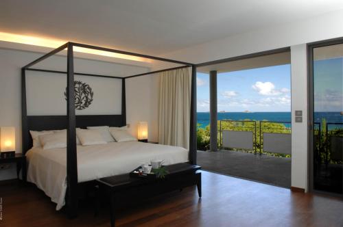 a bedroom with a bed and a view of the ocean at Dream Villa Flamands 606 in Anse des Cayes