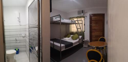 Mały pokój z łóżkiem piętrowym i stołem w obiekcie Rain Haven Lodging House w mieście Coron