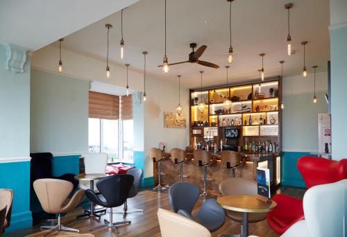 a restaurant with chairs and tables and a bar at Marine Lodge in Great Yarmouth