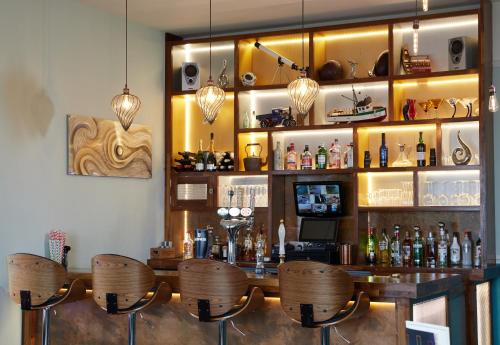 a bar with chairs and a counter with alcohol at Marine Lodge in Great Yarmouth