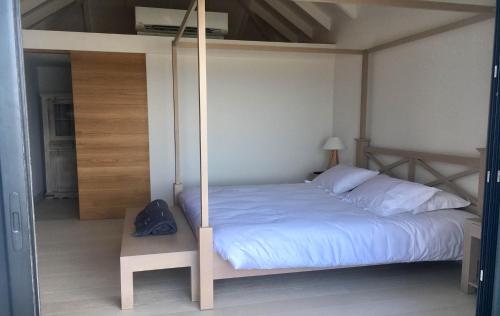 a bedroom with a white bed with a wooden canopy at Dream Villa Vitet 1346 in Gustavia