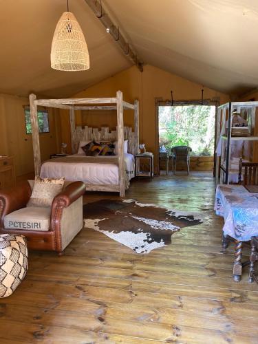 1 dormitorio con 1 cama y 1 sofá en Rhino's Retreat en Waipapa