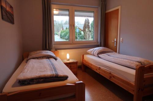 Duas camas num pequeno quarto com uma janela em Ferienwohnung Wildung em Lüneburg
