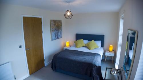 um quarto com uma cama com duas almofadas amarelas em Three Bedroom Townhouse with Parking em Telford