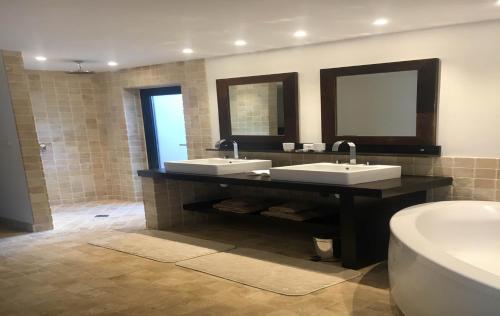 a bathroom with two sinks and a toilet and a mirror at Dream Villa Vitet 1346 in Gustavia