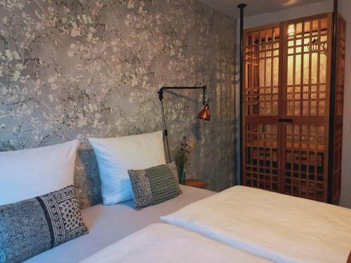 a bedroom with two beds and a wall with flowers at 36 Phô Cô Hotel & Suites in Weimar