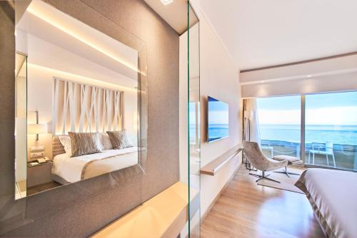 a bedroom with a bed and a view of the ocean at Rodos Palace Hotel in Ixia