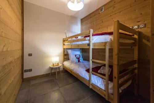 two bunk beds in a room with a lamp at ODYSSEE DRJ04 - Appartement avec grande terrasse sur les pistes in La Toussuire