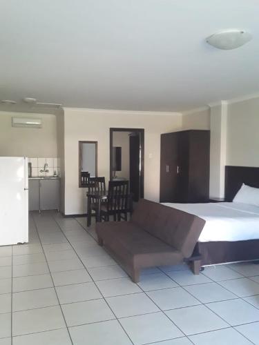 una camera con un letto e un divano di Bayside Hotel Empangeni a Empangeni