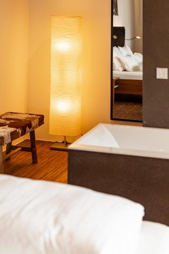 a bedroom with a bed and a lamp and a mirror at Kronplatz LOFT Bruneck in Brunico