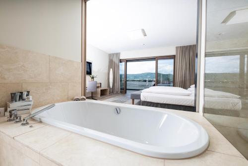a large bathroom with a tub and a bedroom at Linde Villas in Maria Wörth